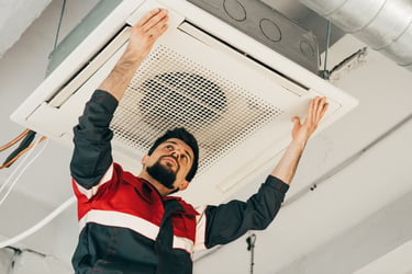 HVAC technician installing a ceiling-mounted air conditioning unit