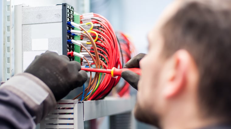 Closeup of electrician contractor works with electric cable wires